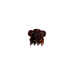 A small amber-brown hair claw clip with a circular floral or mouse-like silhouette and tiny clear rhinestone accents, centered on a plain white background.