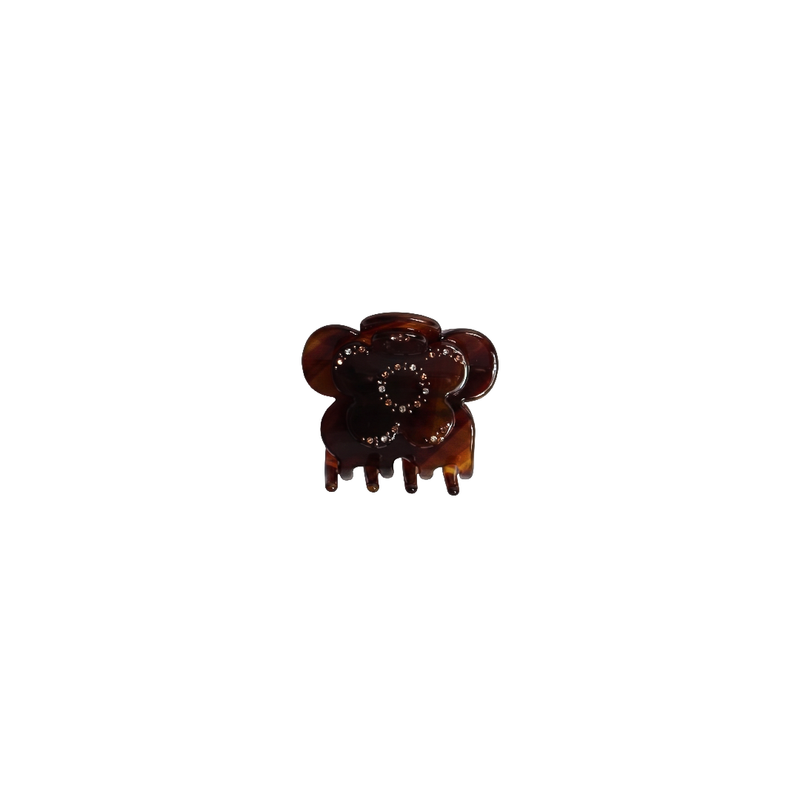 A small amber-brown hair claw clip with a circular floral or mouse-like silhouette and tiny clear rhinestone accents, centered on a plain white background.