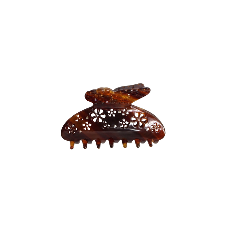 A tortoiseshell hair claw clip with floral cutout details and a butterfly-shaped top, shown on a plain white background.